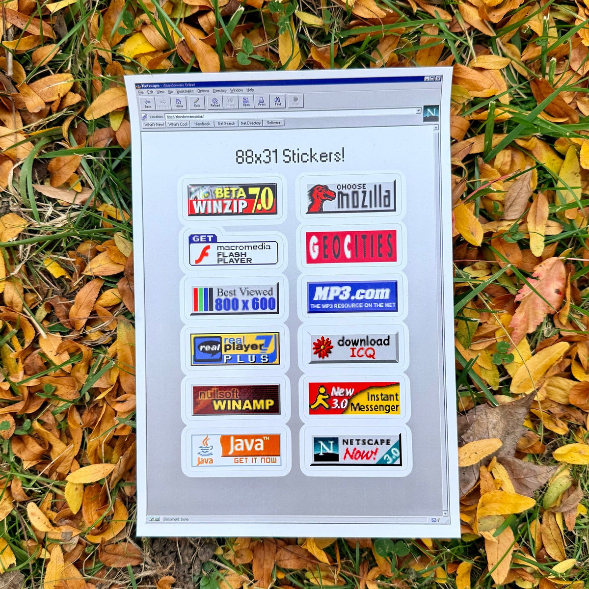 88x31 Web Button Sticker Sheet on fall leaves, styled as a Netscape browser window holding twelve web button stickers