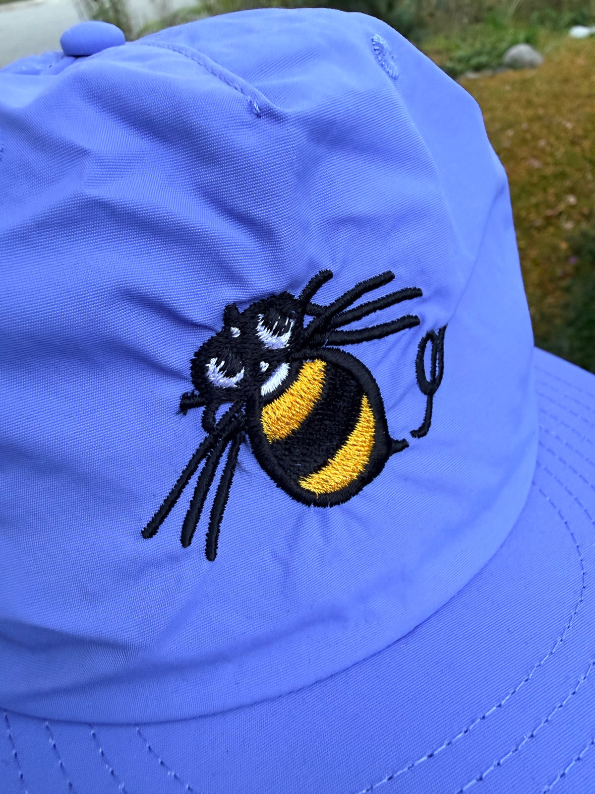 Close-up of the embroidered Hudson Soft bee on the lapis nylon surf cap
